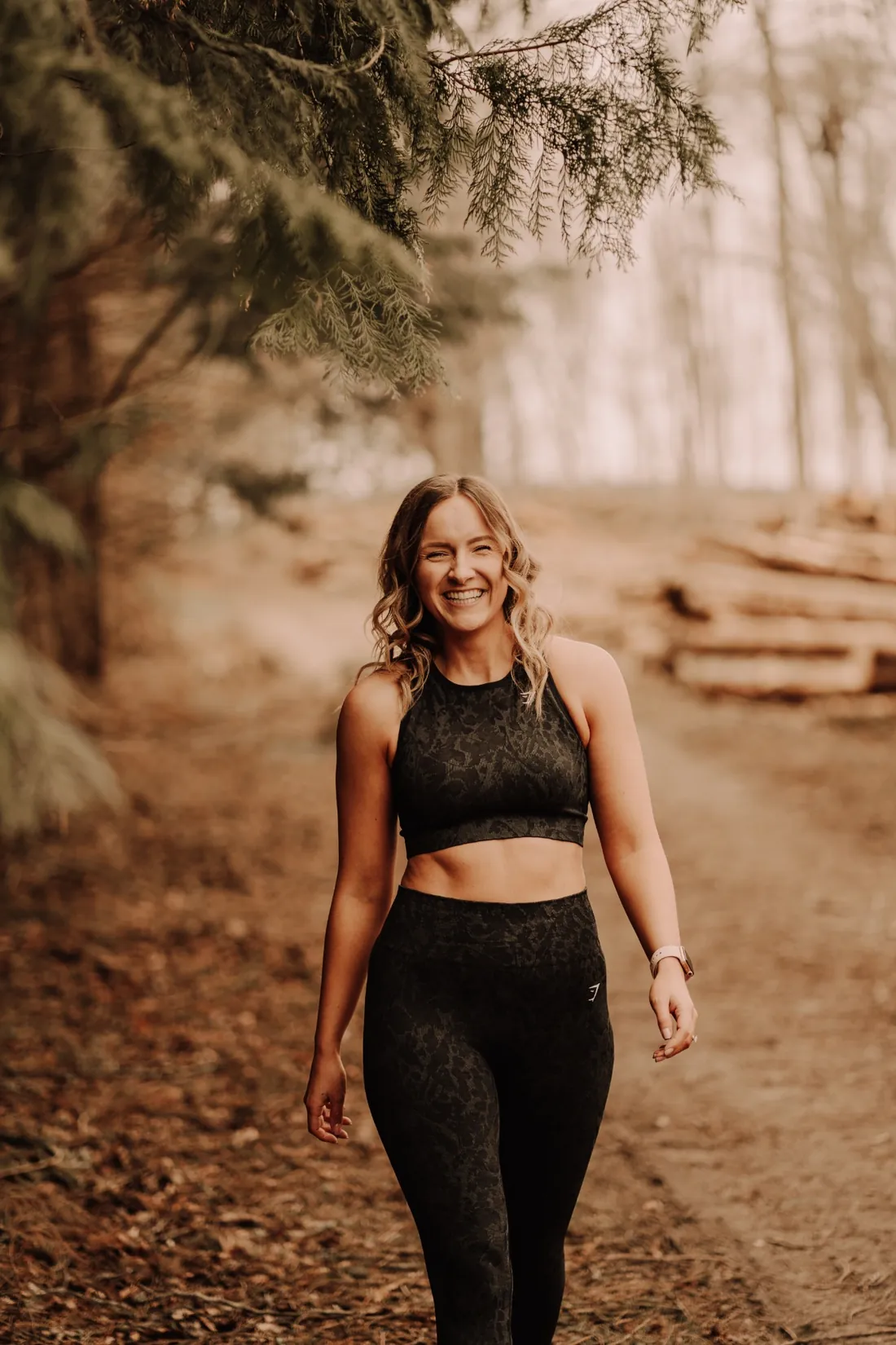 Claire laughing as she walks along a woodland path