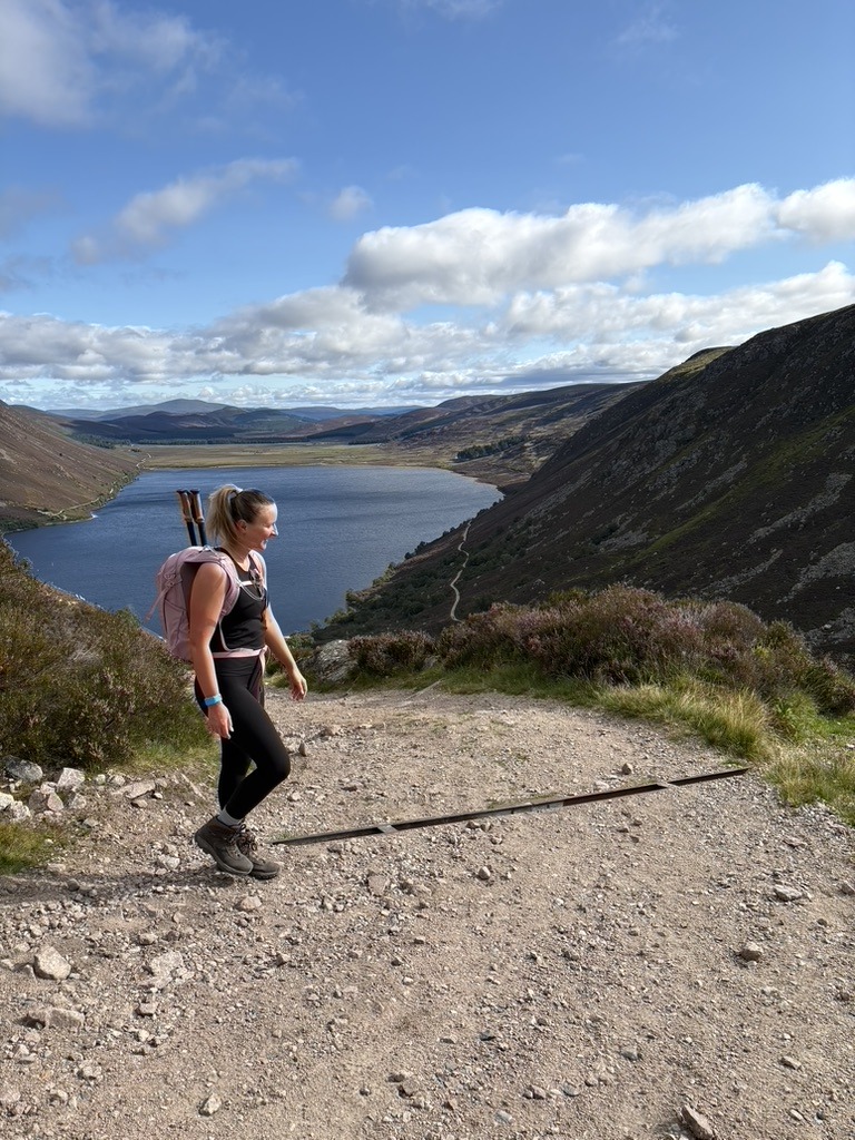 Claire hiking above a loch in the Cairngorms